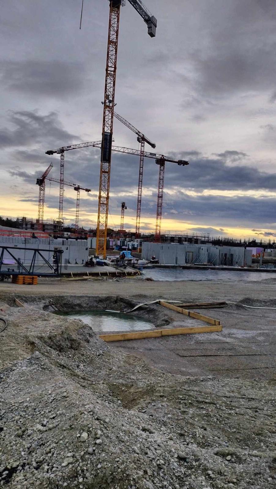 Tiefbau — Baugrube mit Kran-Skyline bei Sonnenaufgang