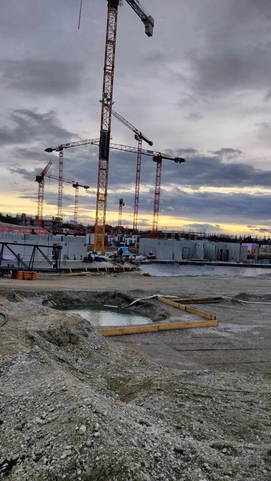 Baukran im Abendlicht über einer Baustelle von Guraziu Bau